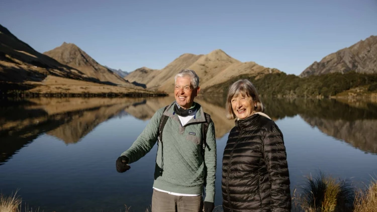Couple walking along the shore at Moke Lake in New Zealand