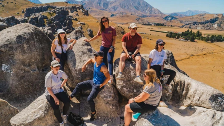 Group of people sitting on the rocks at Castle Hill in New Zealand