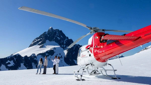 Group of people with a helicopter on a glacier in New Zealand