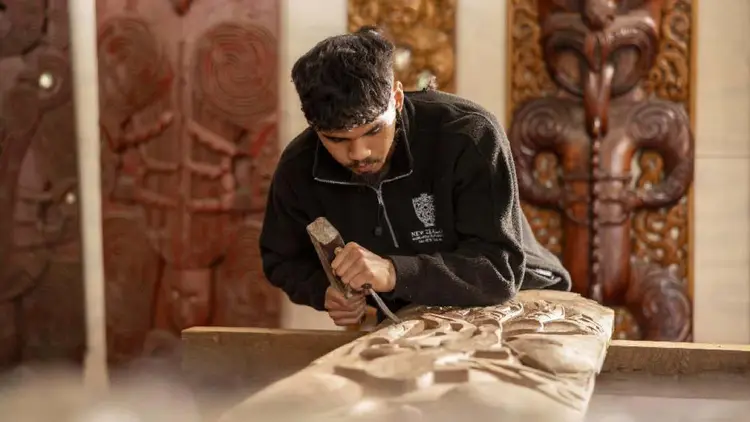 Man creating a traditional Maori wood carving
