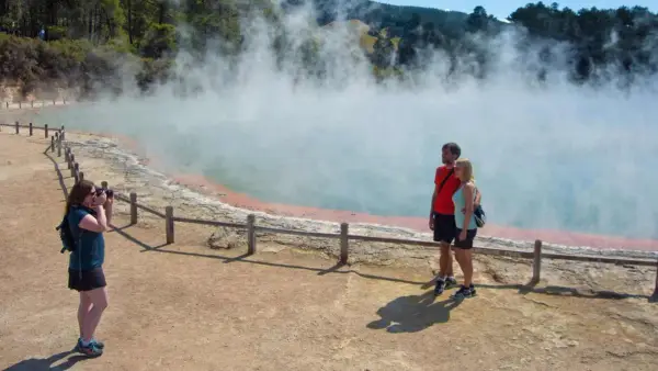 Couple pose for a photo at Wai-O-Tapu in Rotorua