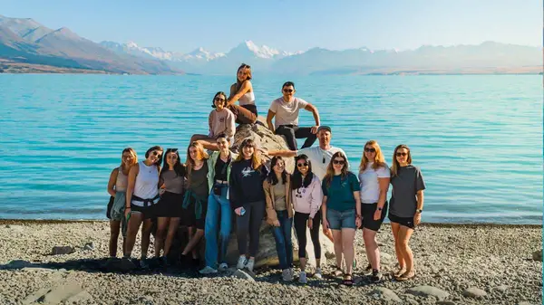 Group of people pose for a photo in front of Lake Tekapo