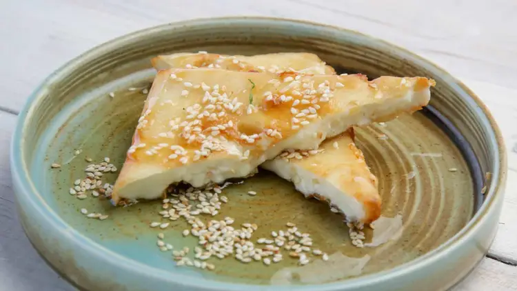 Sheep's cheese with honey and sesame seeds on a plate