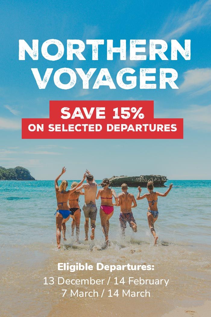 Group of people running into the water at Cathedral Cove