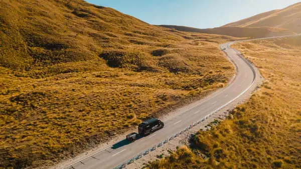 Wild Kiwi vehicle driving through Haast Pass in New Zealand