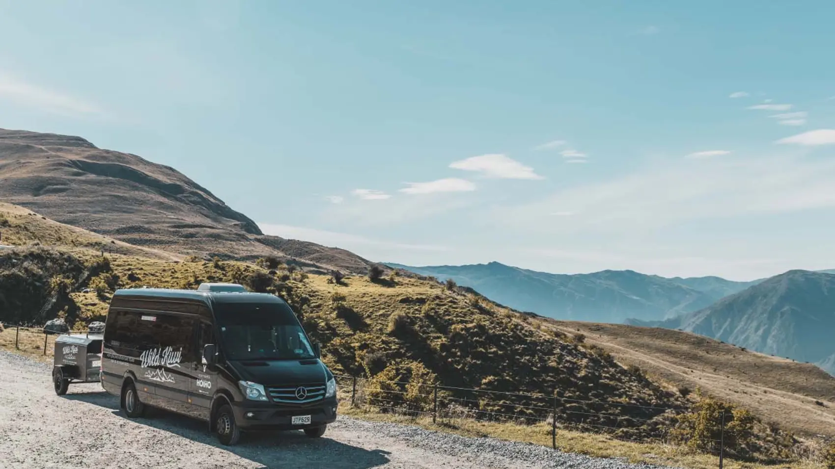 Wild Kiwi Tours vehicle parked by the side of the road in New Zealand