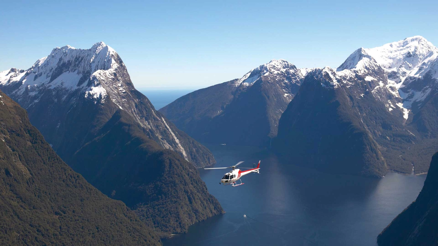 Helicopter flying through Milford Sound 