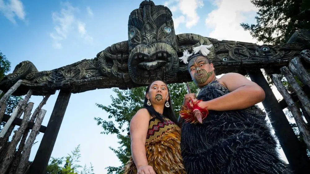 Māori man and woman greet visitors at Mitai Māori Village