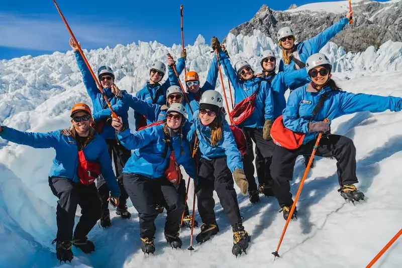 A group of young travellers on the Franz Josef heli-hike standing atop Franz Josef glacier in New Zealand.