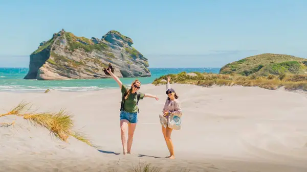 Two people pose for a photo at Golden Bay beach