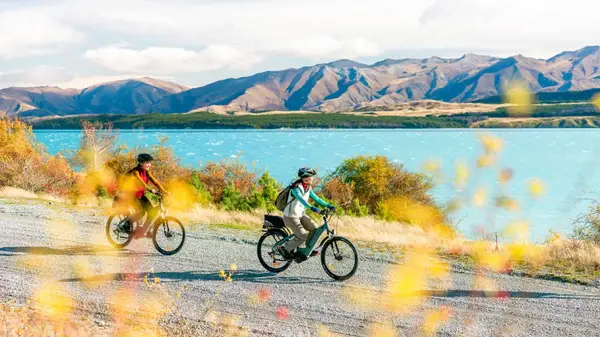 Two women cycling next to Lake Tekapo