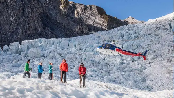 Group of people on Franz Josef glacier with a helicopter