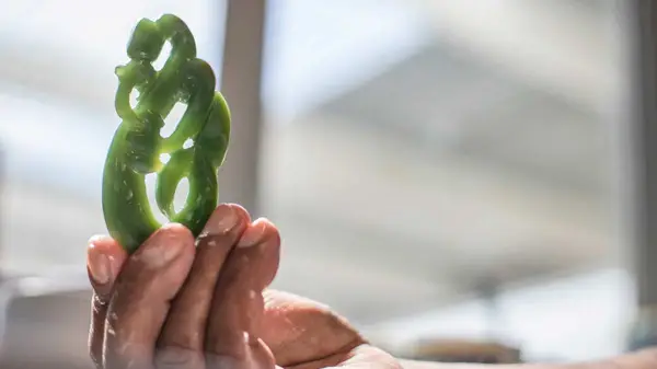 Man holding a pounamu carving