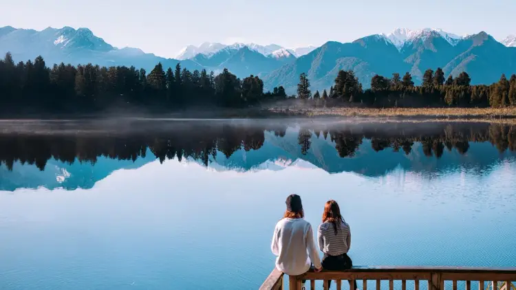 Couple look out at mirror lakes in New Zealand