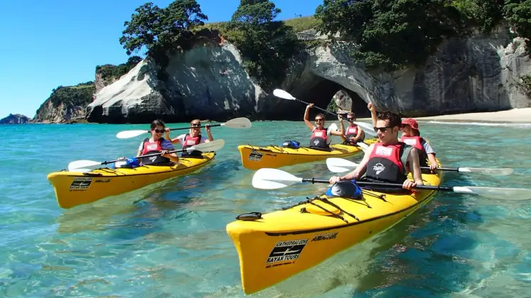 Group of people kayaking at Cathedral Cove in New Zealand