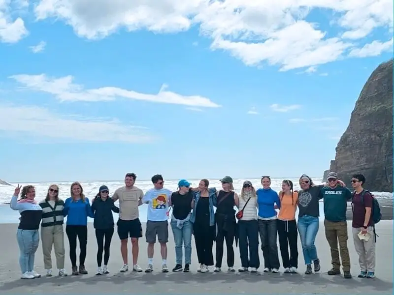Wild Kiwi group exploring a remote New Zealand beach on a small-group adventure tour, enjoying coastal scenery in a relaxed and safe setting.