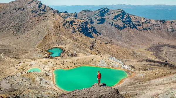 Person overlooking the green lakes in Tongariro National Park