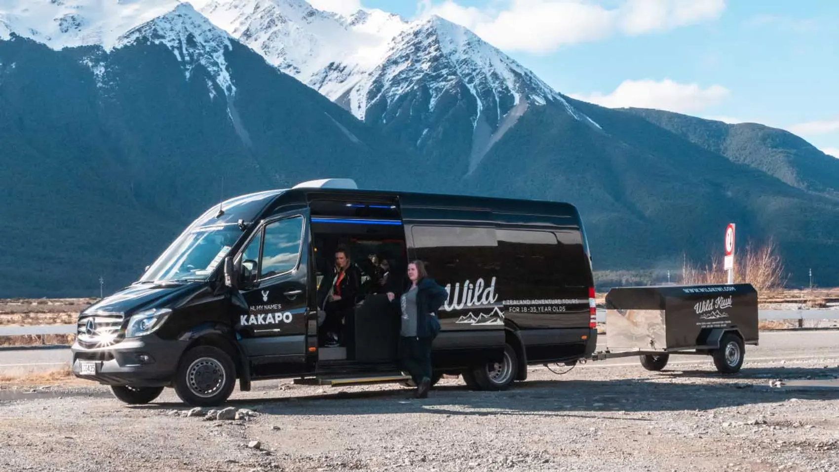 Wild Kiwi tour vehicle parked in front of some mountains