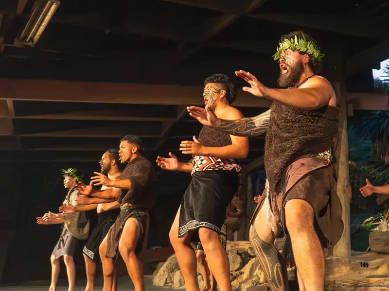 Māori performers sharing a traditional cultural performance indoors on New Zealand’s North Island, highlighting Māori heritage, storytelling and cultural experiences as one of the key reasons travellers may choose the North Island when comparing North Island vs South Island New Zealand.