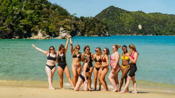 Group of women pose for a photo after a swim at Abel Tasman National Park