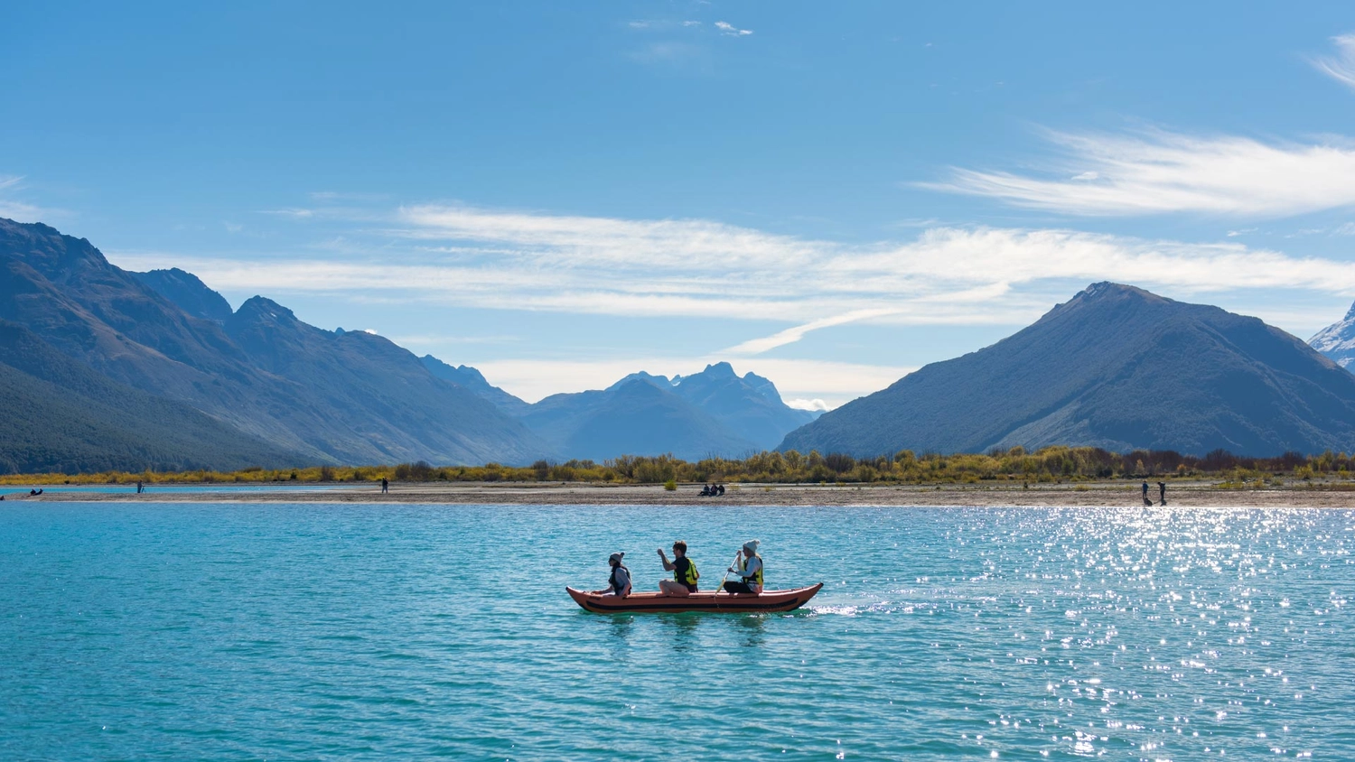 Three people on a kayak in Lake Wakatipu in New Zealand