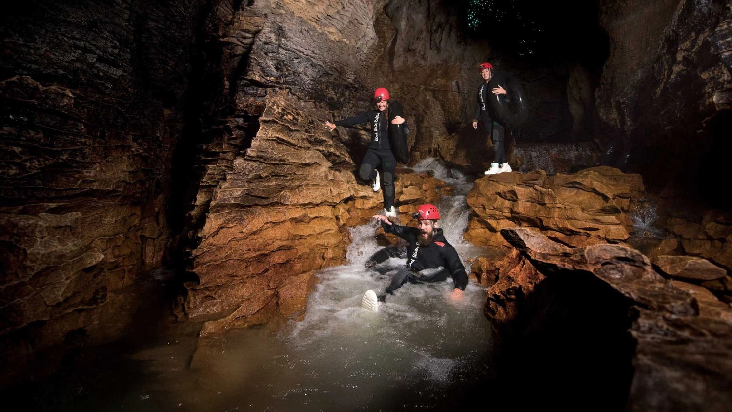 Group of people black water rafting in Waitomo