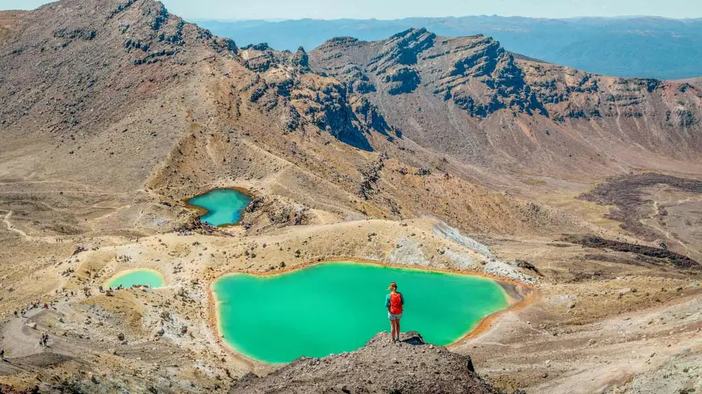 Person in front of an emerald lake on the Tongariro Crossing