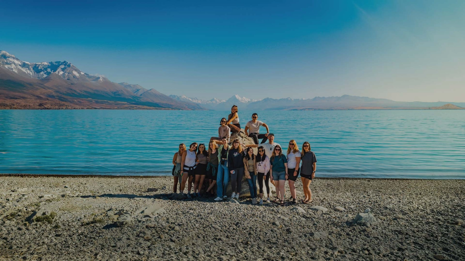 Group of friends pose for a photo in front of Lake Tekapo