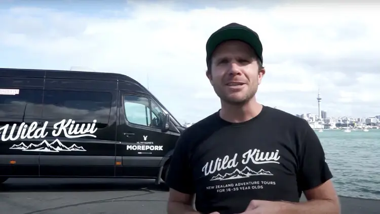 Wild Kiwi Tours guide standing in front of the tour bus