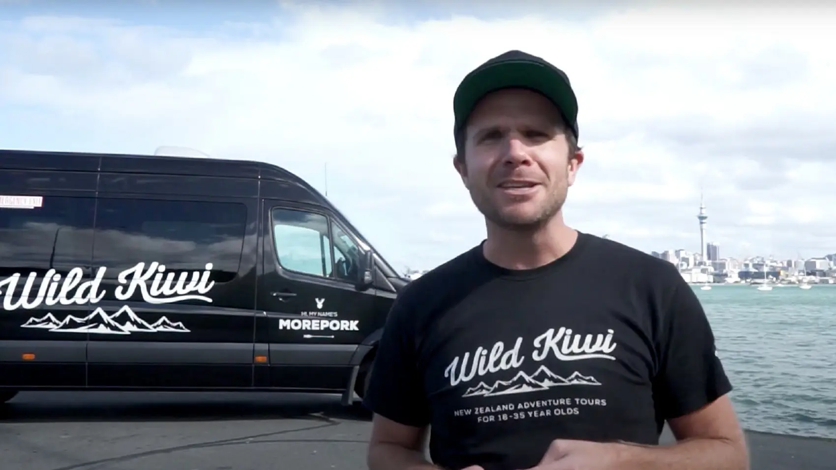 Wild Kiwi Tours guide standing in front of the tour bus