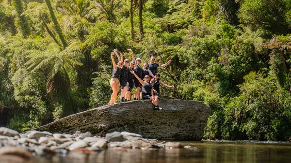 Group of people pose for a photo on a large rock