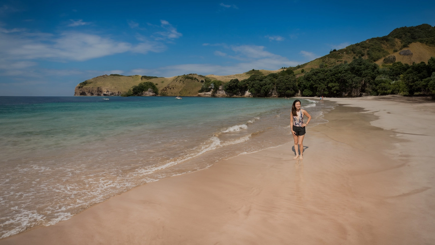 Woman standing on the beach at Cathedral Cove in New Zealand