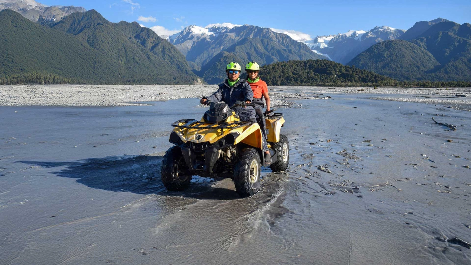 Tandem quad biking in a river bed in Franz Josef