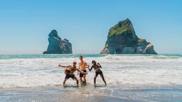 People in the surf at Golden Bay