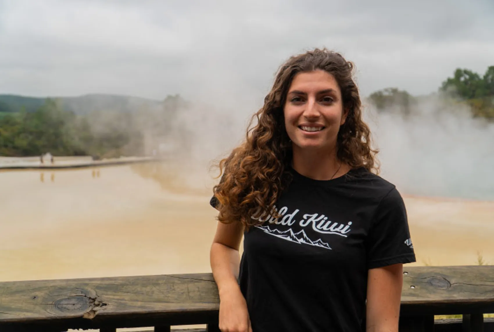 Image of a Wild Kiwi guide standing in front of mud pools in Rotorua