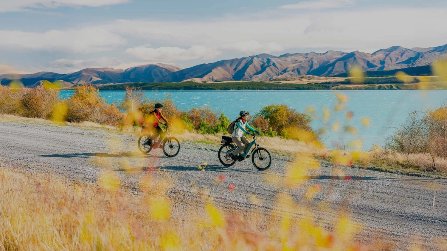 Two people cycling next to Lake Pukaki
