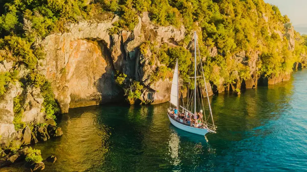 Yacht in front of Māori carvings on Lake Taupo