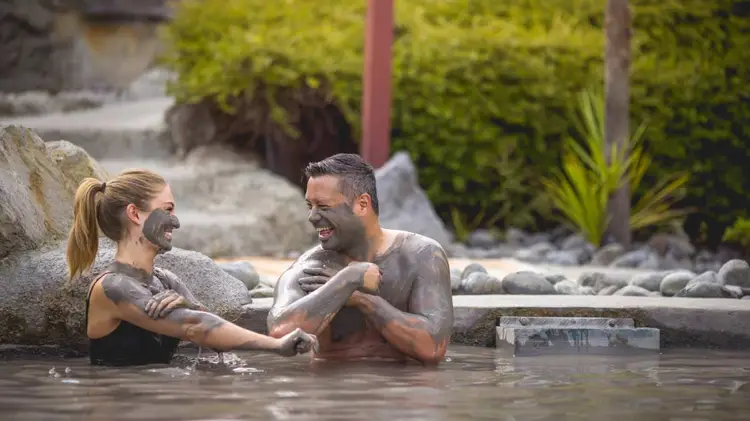 Two people in the mud pools at the Polynesian Spa