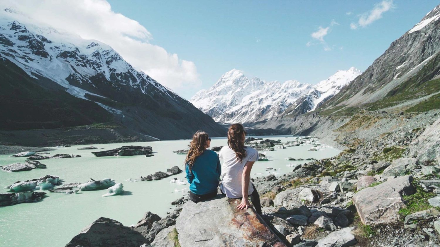 Two people look out at Mueller Glacier and Mount Cook