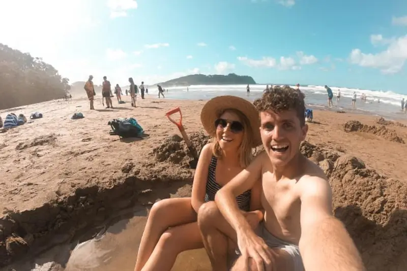 Couple enjoy water pool at Hot Water Beach in New Zealand