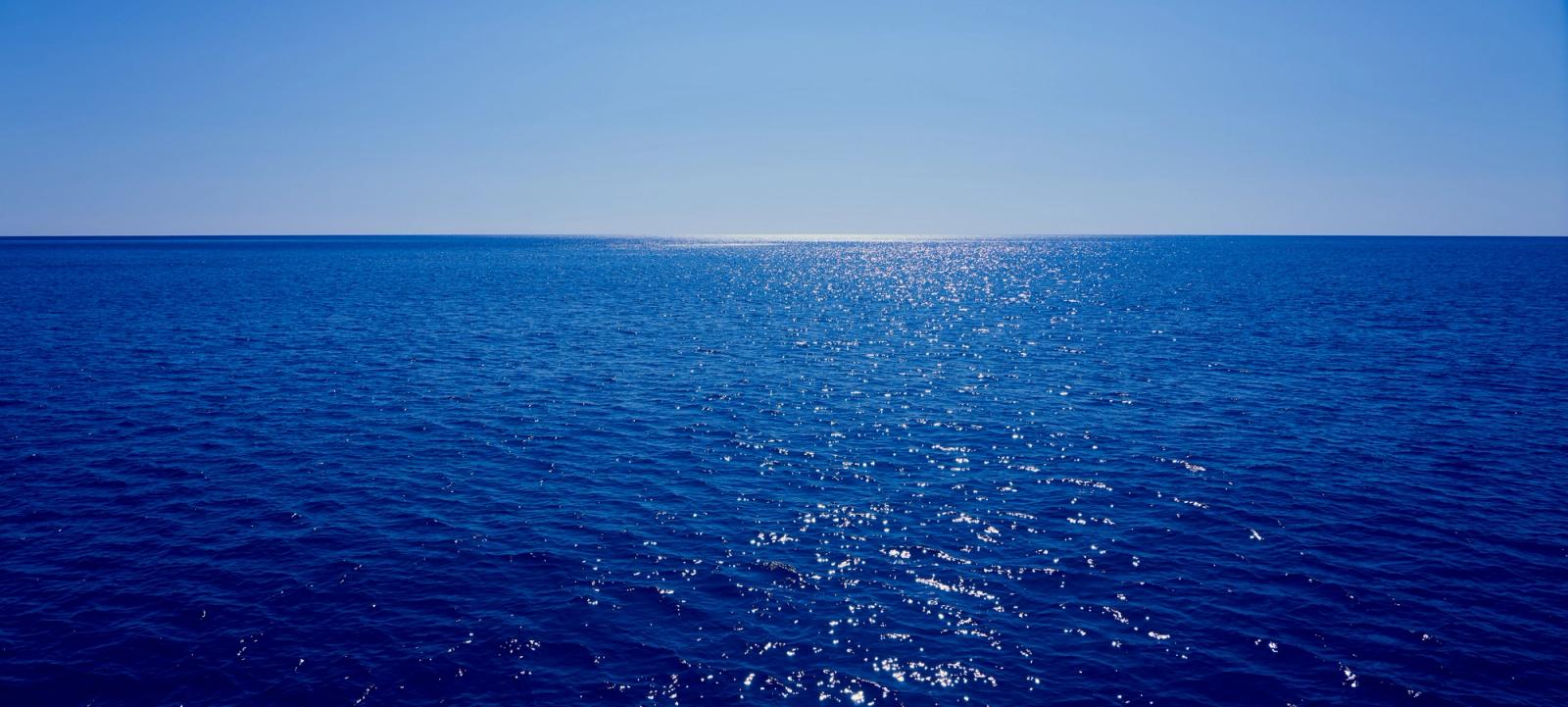 Open ocean stretching to the horizon under a clear blue sky