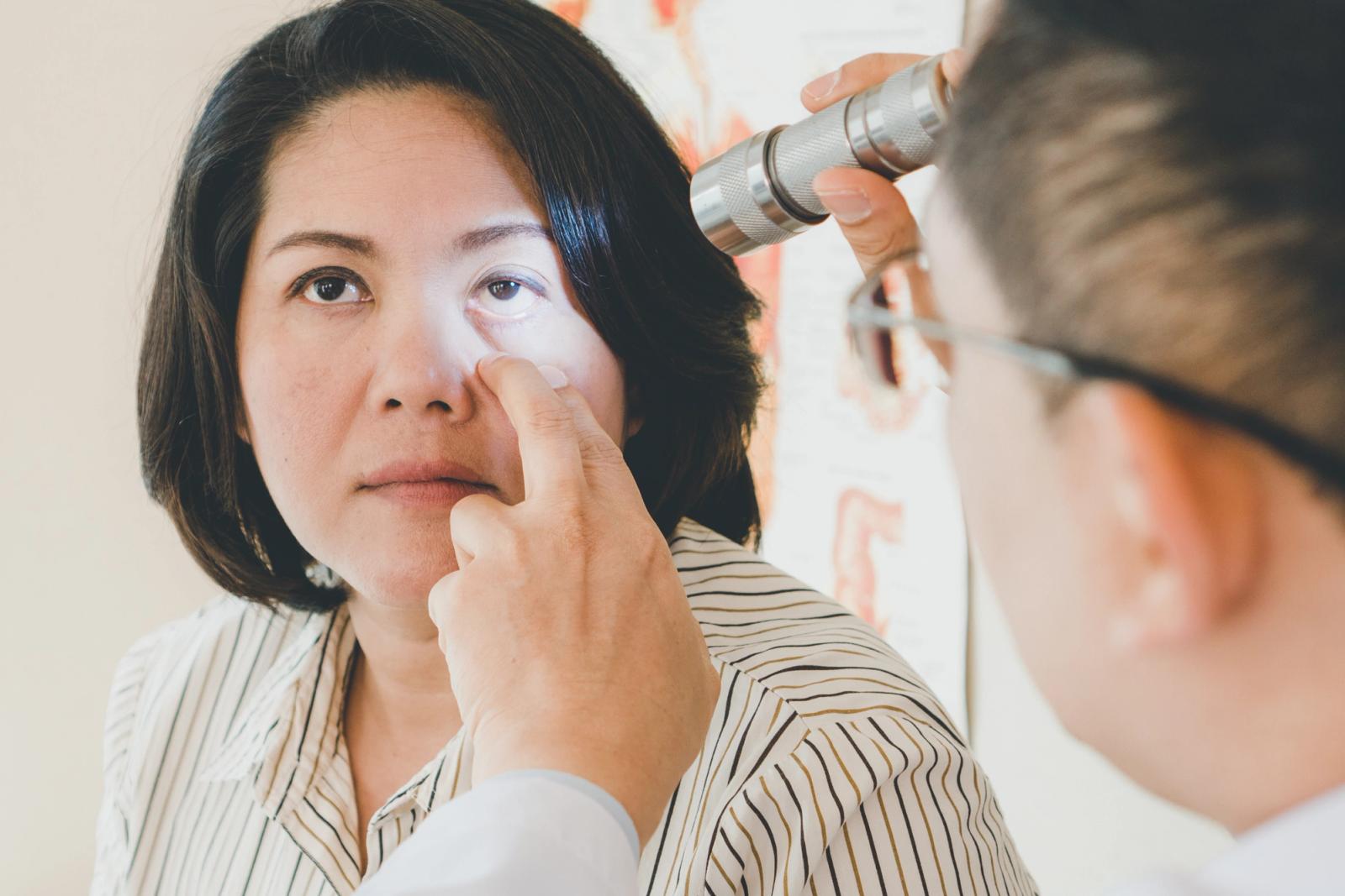 A clinician gently examines a patient's lower eyelid during an eye examination at a clinic