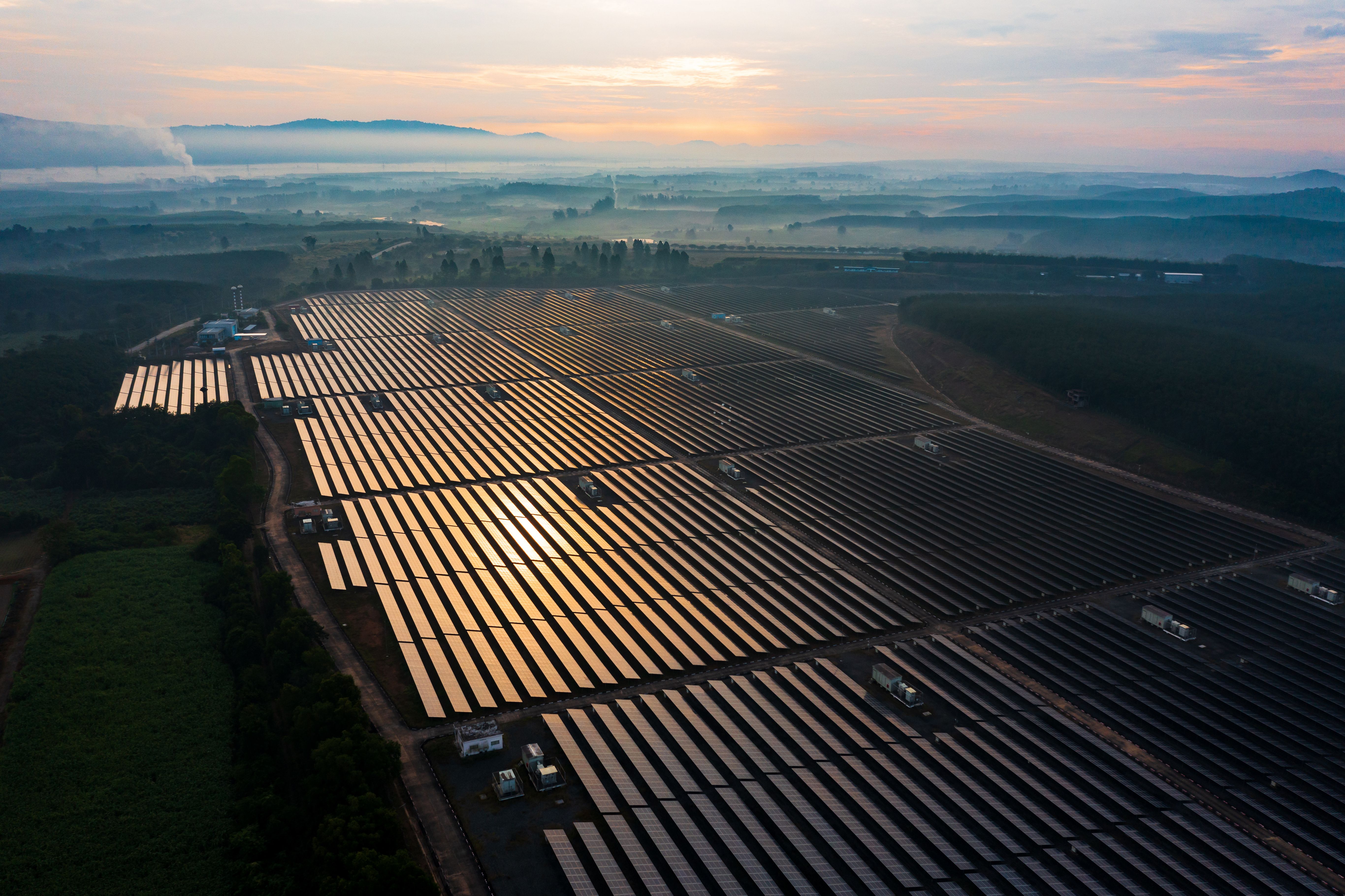 Aerial view of a large solar farm at sunrise