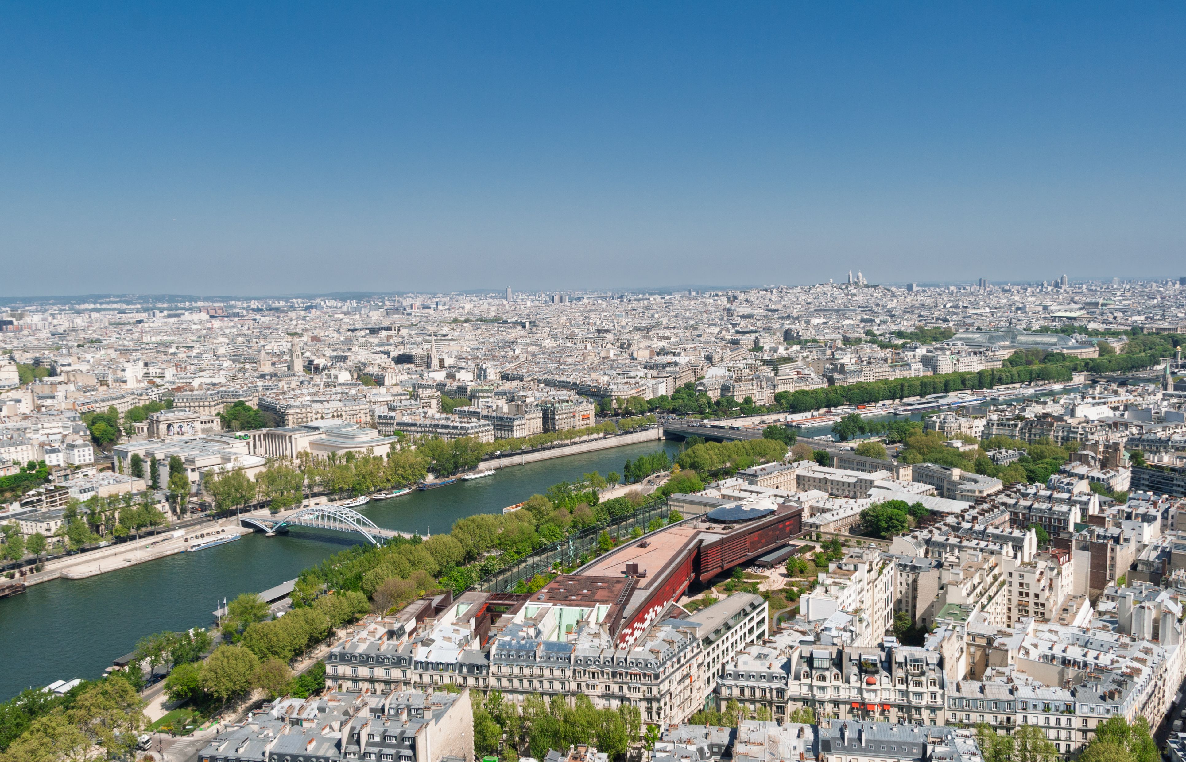 Aerial view over central Paris and the river Seine under a clear blue sky