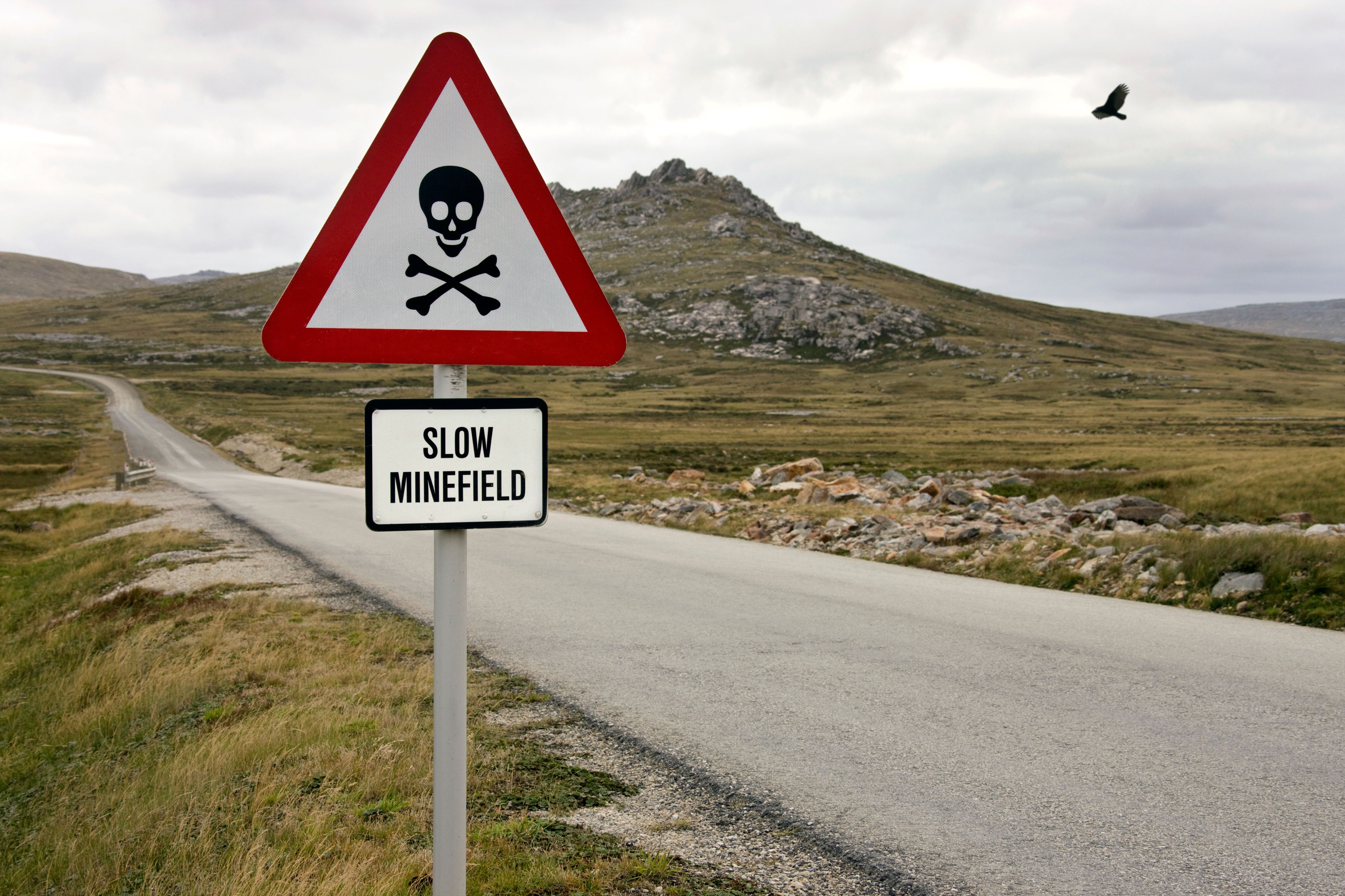 A minefield warning sign in a field