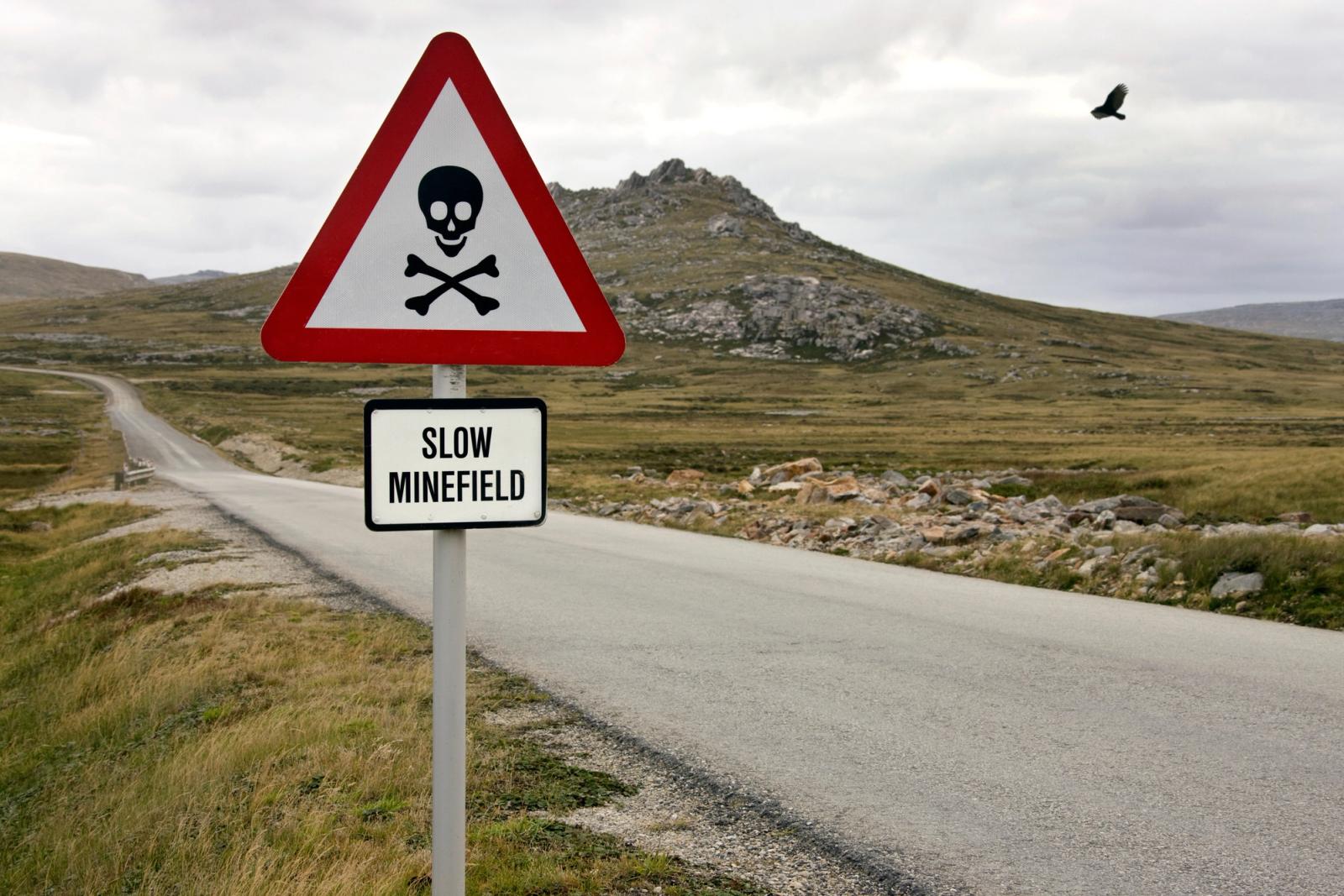 A minefield warning sign in a field