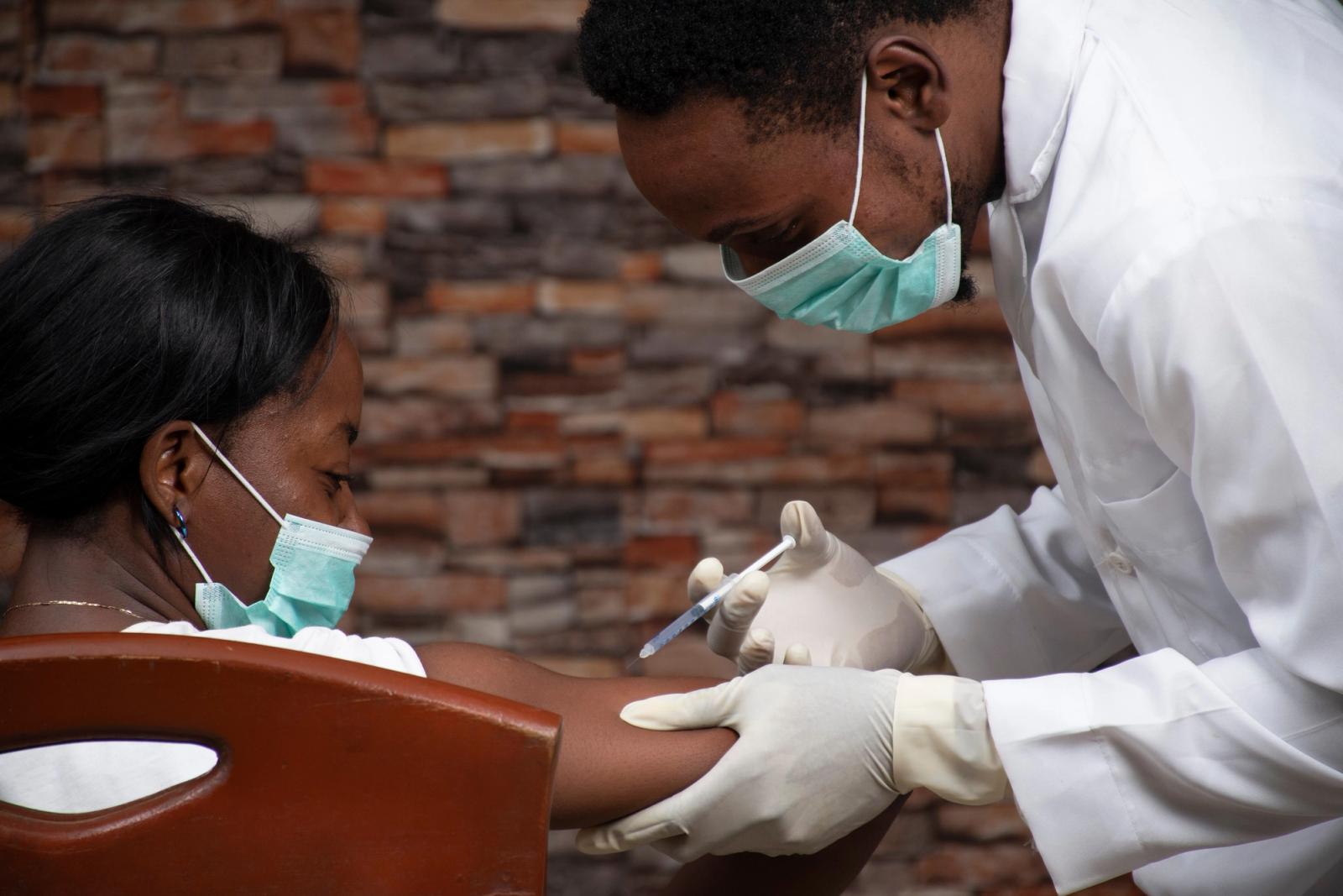A health worker administers a vaccine to a patient at a clinic