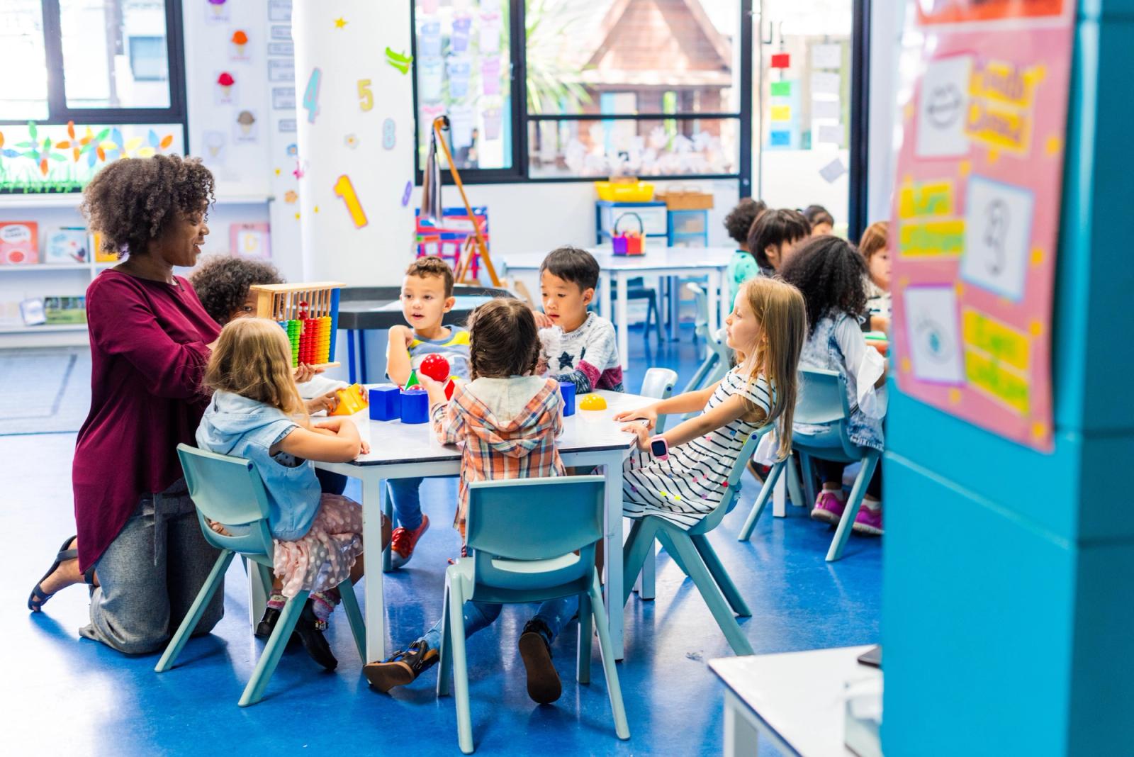 Young children learning together with their teacher in a primary school classroom