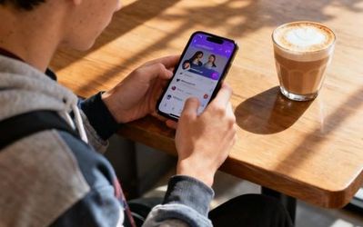 Young person using dating app on smartphone with coffee in hand