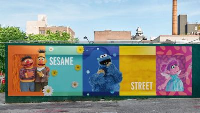 Wide, patterned billboard design reading "Sesame Street" with Bert, Ernie, Cookie Monster, and Abby Cadabby